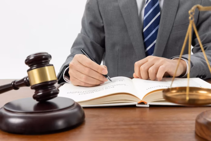 closeup-shot-person-writing-book-with-gavel-table_181624-57173