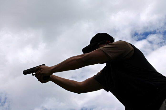 low-angle-view-man-shooting-gun-against-sky_1048944-22789183