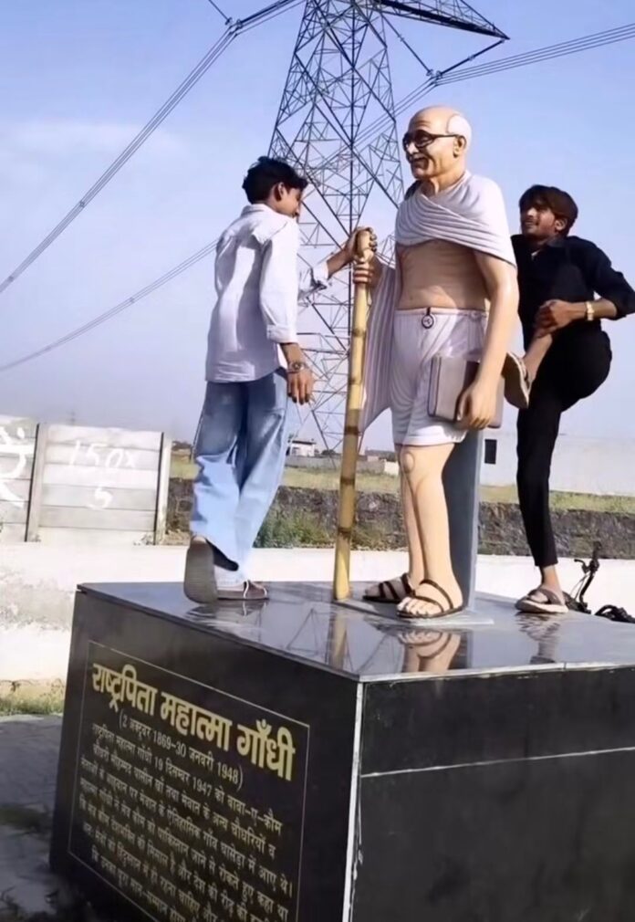 महात्मा गांधी की प्रतिमा के साथ युवकों का अपमान महात्मा गांधी की प्रतिमा के साथ युवकों का अपमान