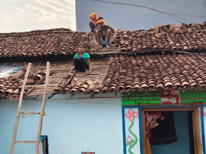 मजदूर खपरैल की मरम्मत करते हुए मजदूर खपरैल की मरम्मत करते हुए