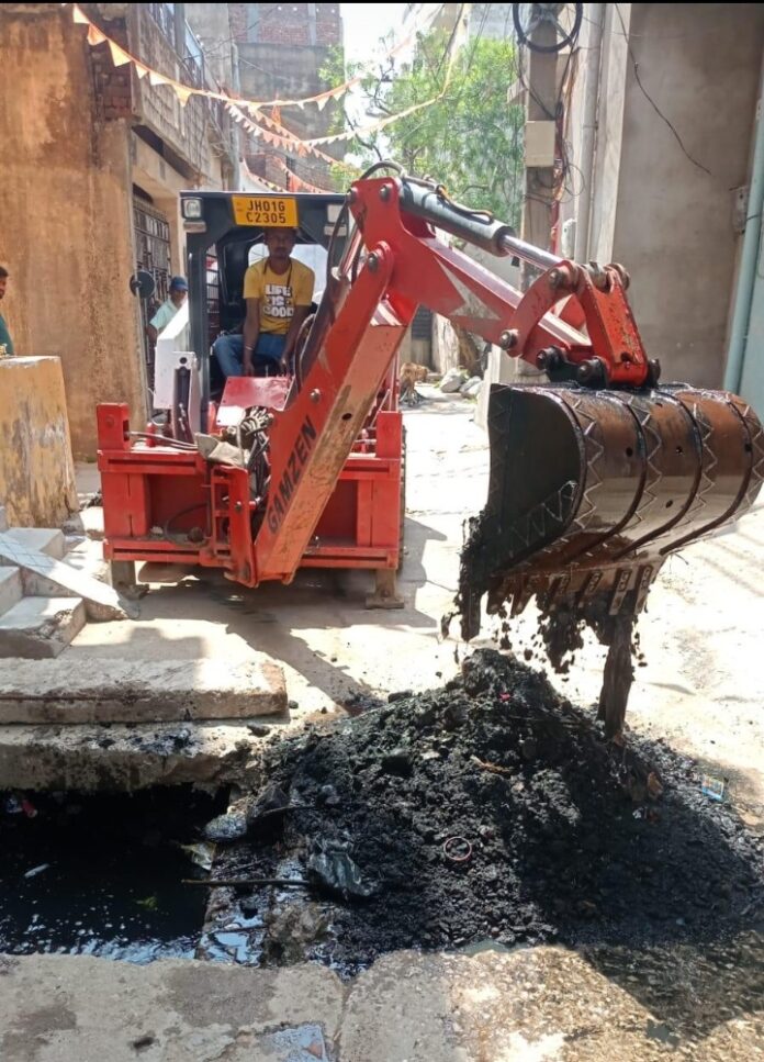 सफाई कार्य में लगाया गया स्किड लोडर (मिनी जेसीबी) मशीन की तस्वीर