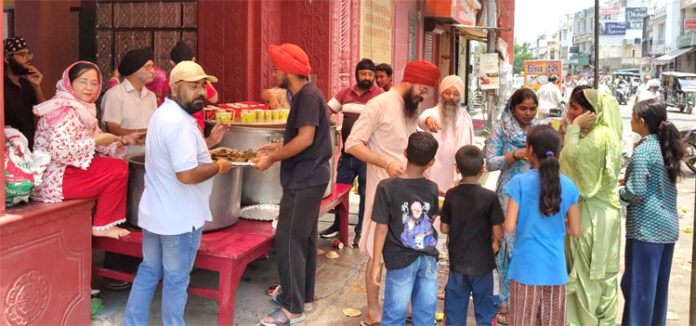 शरबत वितरित करते हुए शरबत वितरित करते हुए