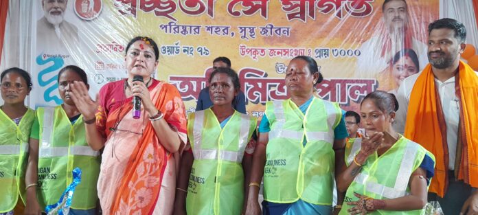 मंत्री सफाई कर्मियों को किट देता है