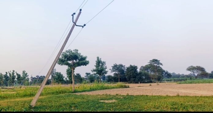खेत में झुका हुआ पोल और किसानों की मुश्किलें