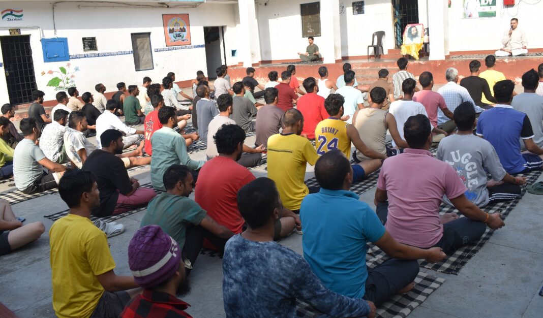 जेल के कैदियों को योग सिखाते हुए