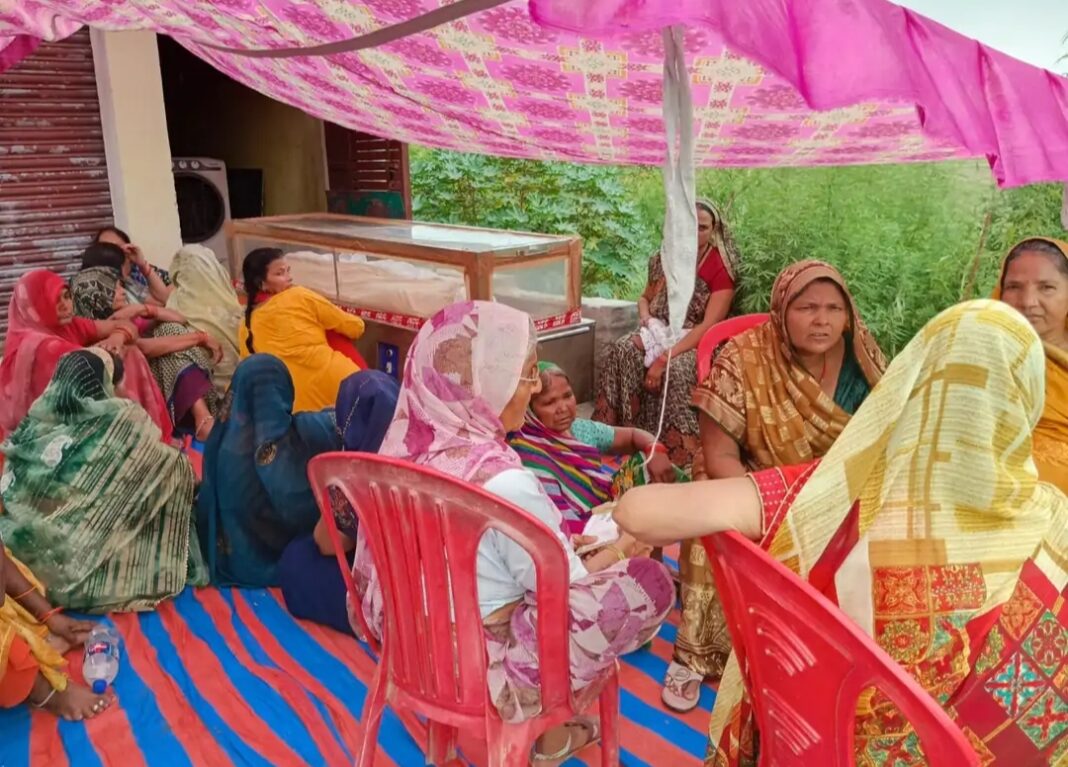 फोटो। घर के बाहर शव के पास बैठे परिजन शव के पास बैठे परिजन