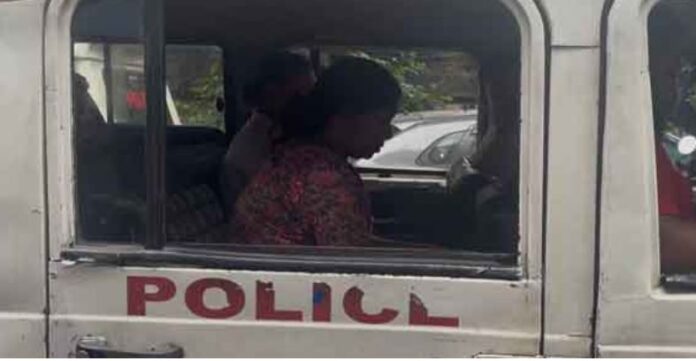 गिरफ्तार युवती को पुलिस की गाड़ी में ले जाती
