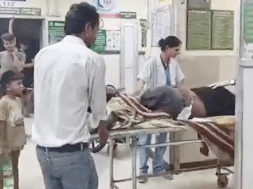 स्वास्थ्य कर्मी घायल युवक का इलाज करते हुए स्वास्थ्य कर्मी घायल युवक का इलाज करते हुए
