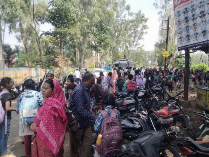 विद्यार्थी बसों का इंतजार करते हुए धूप में खड़े विद्यार्थी बसों का इंतजार करते हुए धूप में खड़े