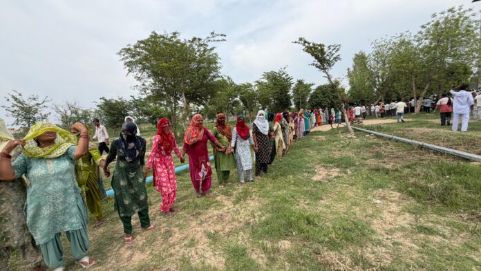 महिलाएं धरनास्थल से जलघर तक मानव श्रृंखला बनाती हुईं
