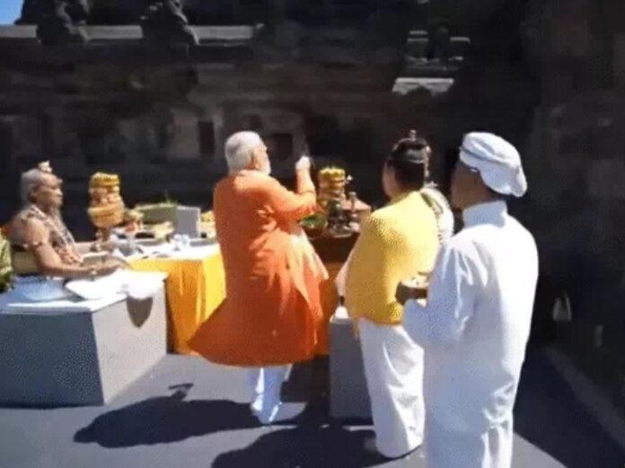 नरेन्द्र मोदी इंडोनेशिया में पूजा करते हुए नरेन्द्र मोदी इंडोनेशिया में पूजा करते हुए