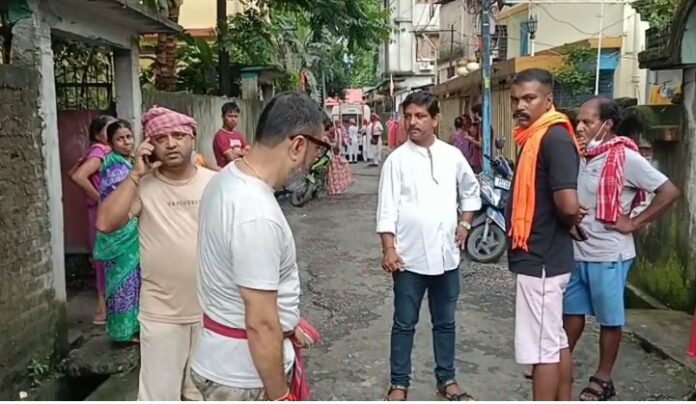 मृत वृद्धा के घर के पास पड़ोसियों की भीड़