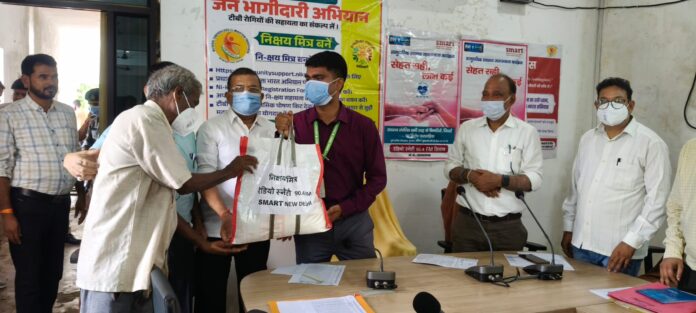 जिलाधिकारी टीबी मरीजों को फूड बॉस्केट देते हुए