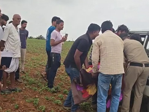 छात्रों के शव को मर्चुरी ले जाते हुए पुलिसकर्मी छात्रों के शव को मर्चुरी ले जाते हुए पुलिसकर्मी