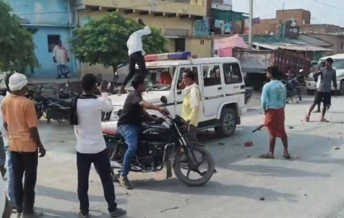 ग्रामीण पुलिस वाहन को क्षतिग्रस्त करते हुए