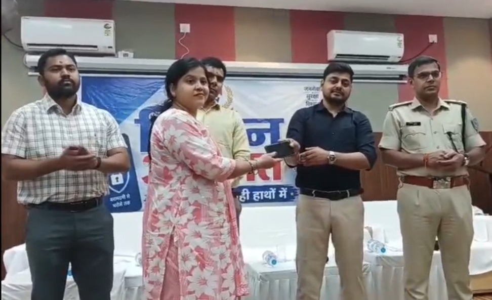 मोबाइल फोन स्वामिनी को उसका फोन देते उपायुक्त और उनके बगल में मौजूद धनबाद एसएसपी मोबाइल फोन वापसी का दृश्य