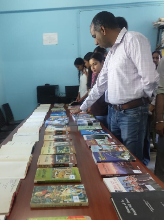 छात्र पुस्तक प्रदर्शनी का अवलोकन करते हुए