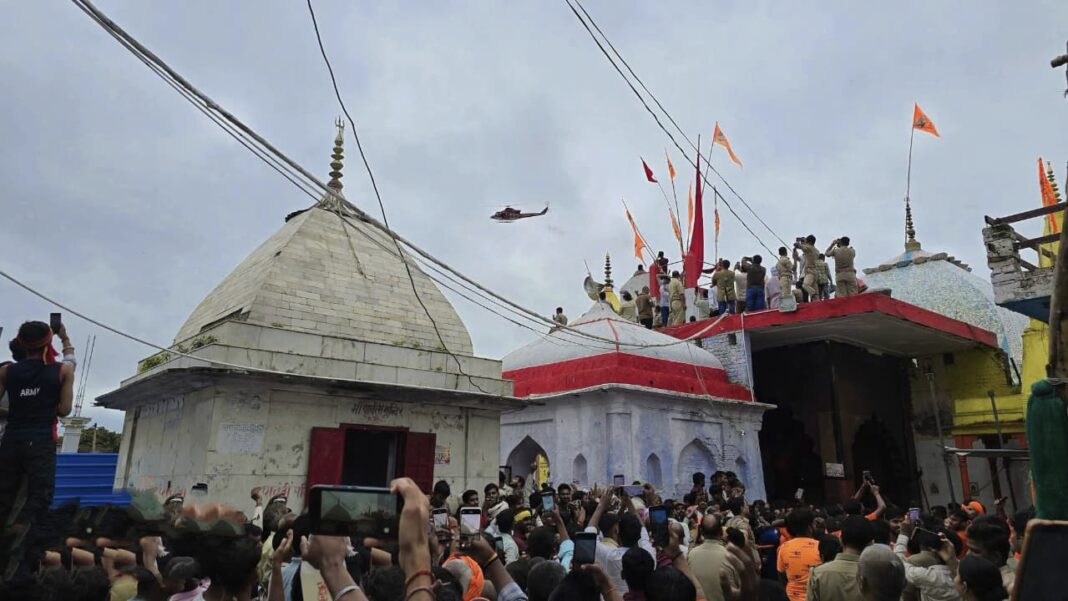 फ़ोटो हेलीकॉप्टर से श्रद्धालुओं को पुष्प वर्षा करते हुए हेलीकॉप्टर से पुष्प वर्षा करते हुए
