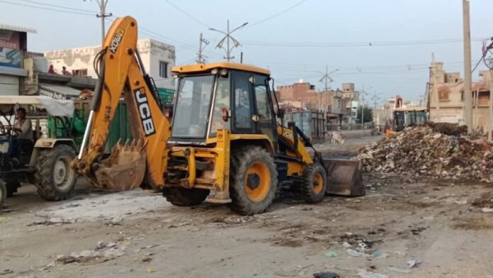 डंपिंग प्वाइंट से कूड़ा उठाती जेसीबी।