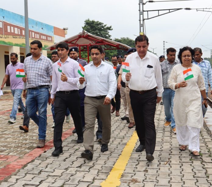 काकोरी रेलवे स्टेशन पर काकोरी स्टेशन महोत्सव के दौरान तिरंगा लेकर हाथों में चलते अधिकारी व रेलकर्मी।