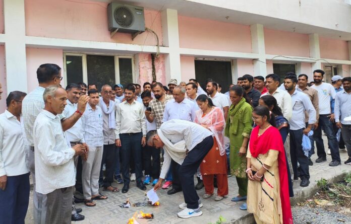 फतेहाबाद। प्रदर्शन कर फैसले की प्रतियां फूंकते बिजली कर्मचारी।