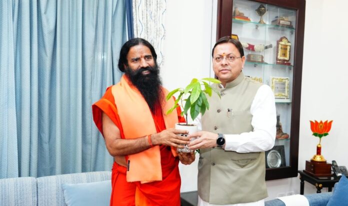 बाबा रामदेव मुख्यमंत्री धामी से भेंट करते ।