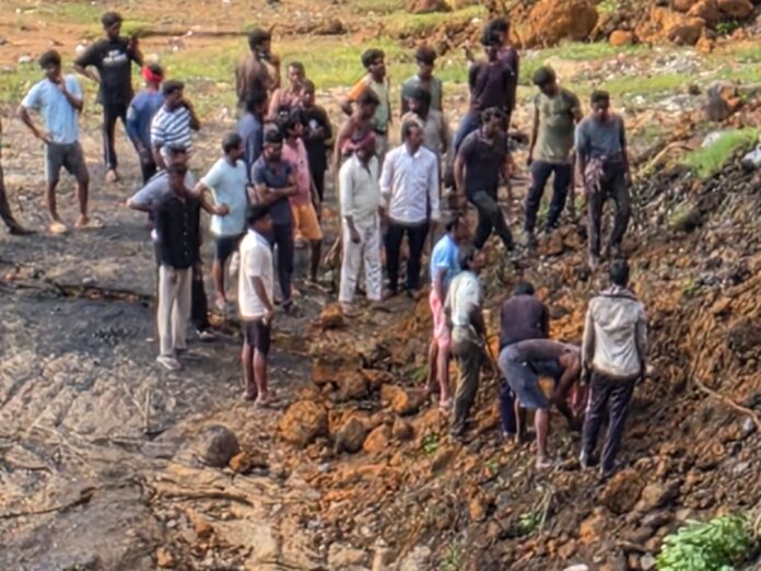 मिट्टी में दबे लोगों को नकालते लोग