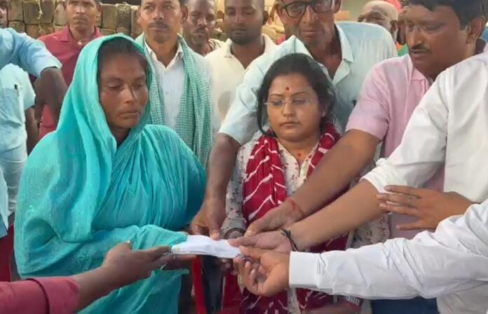 पीड़ित को चेक देते महासभा के लोग