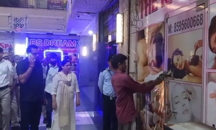 गुरुग्राम के सफायर मॉल 90 में छापेमारी के दौरान एक स्पा सेंटर का लॉक कटवाती हरियाणा महिला आयोग की चेयरपर्सन ऊषा प्रियदर्शी।