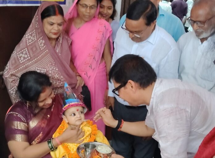 बच्चे का अन्नप्राशन कराते विधायक अनुराग सिंह व अन्य।