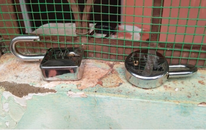 जांच करते पुलिस पदाधिकारी, दरवाजा का टूटा ताला और कुंडा