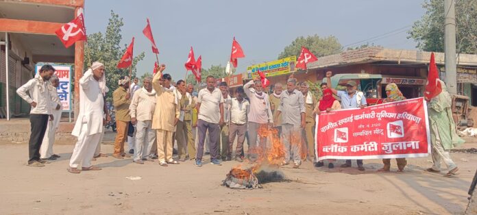 सरकार का पुतला फूंकते ग्रामीण सफाईकर्मी।