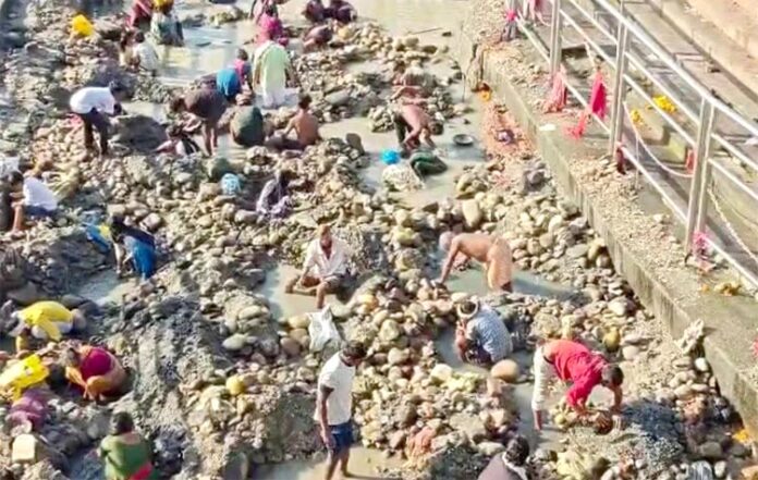 जलविहिन हरकी पैड़ी ओर उसमें सामान ढूढ़ते लोग
