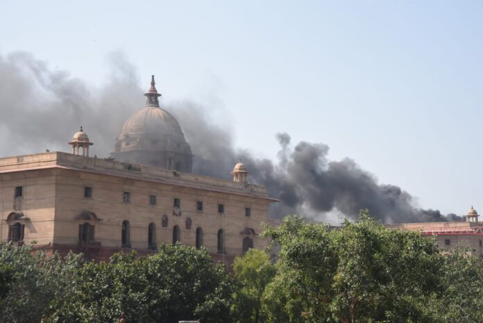 नई दिल्ली में सोमवार को नॉर्थ ब्लॉक की छत पर निर्माण कार्य के दौरान वेल्डिंग से उठे धुएं का दृश्य।