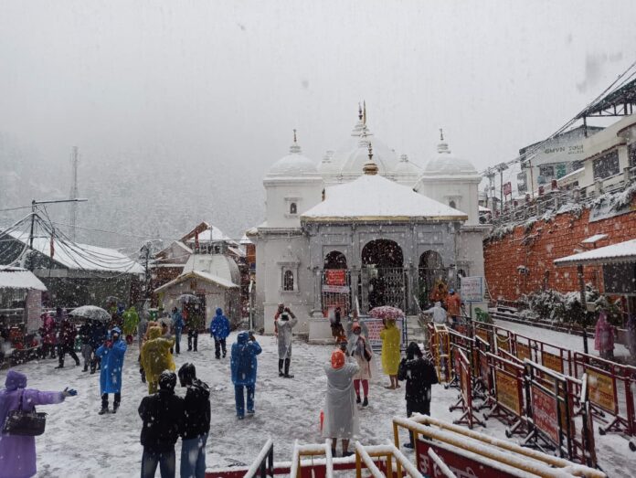 टो कैप्शन: गंगोत्री धाम में गुरुवार को बर्फबारी के बीच दर्शन करते श्रद्धालु।